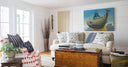 Coastal living room, hand-sketched beach wash ashores brought to life on 100% Belgian linen pillows and Mermaid's purse fabric in nantucket red on upholstered chair