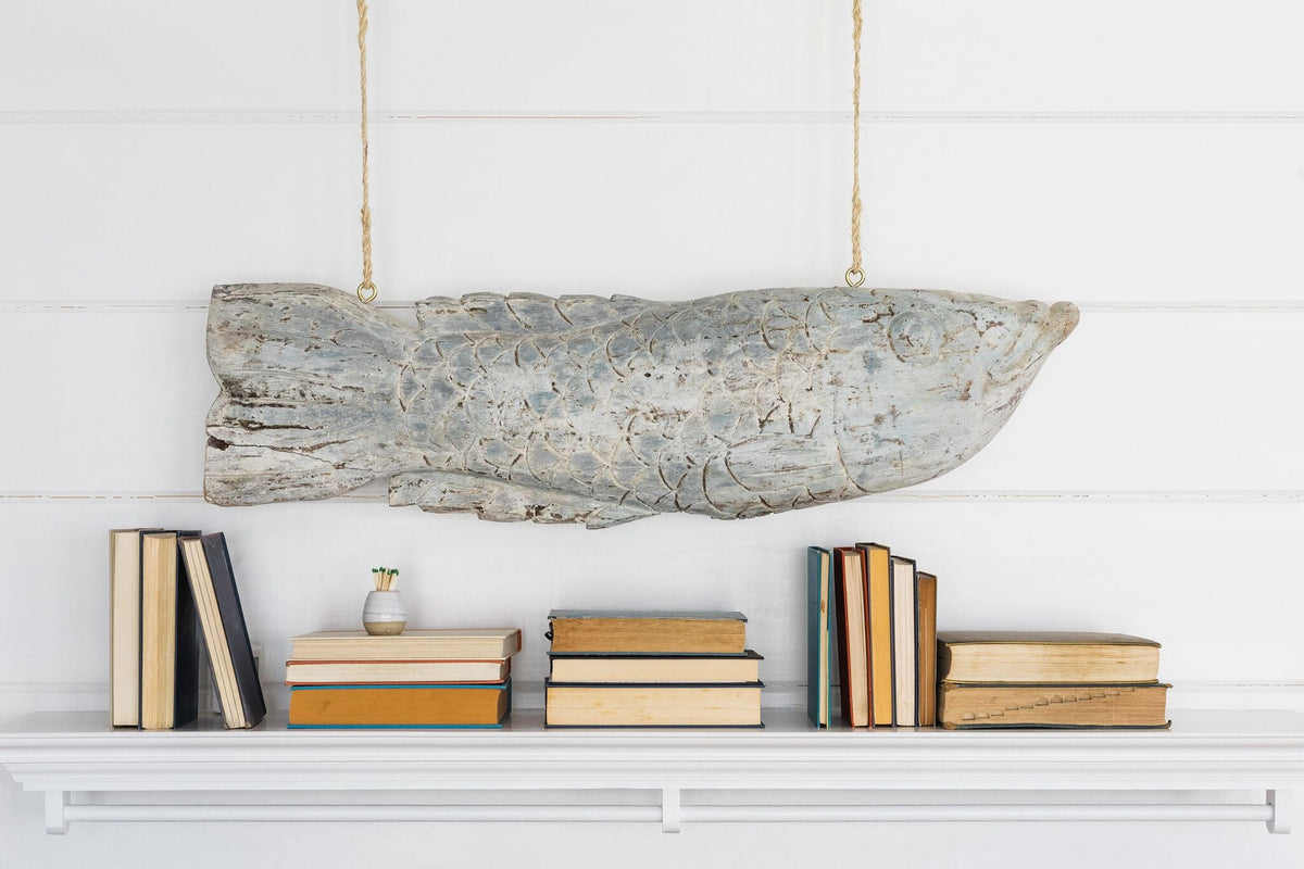 A hand-carved wooden cod fish hanging over the mantel at Laughing Gull Hill