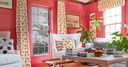 Coastal room painted in Nantucket Red with accent pillows and curtains from Laughing Gull Hill
